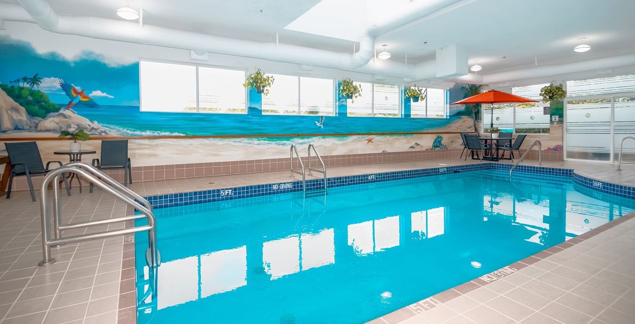 Hotel indoor pool with poolside table and umbrella