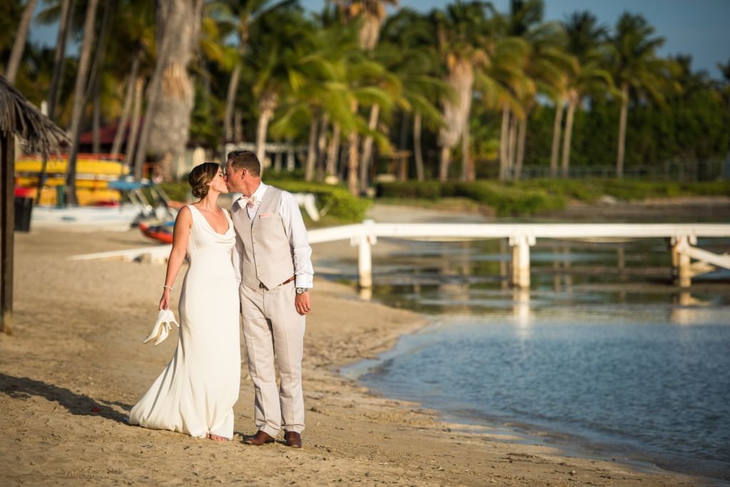 A wedding couple kissing on a Copa Beach at Copamarina Weddings