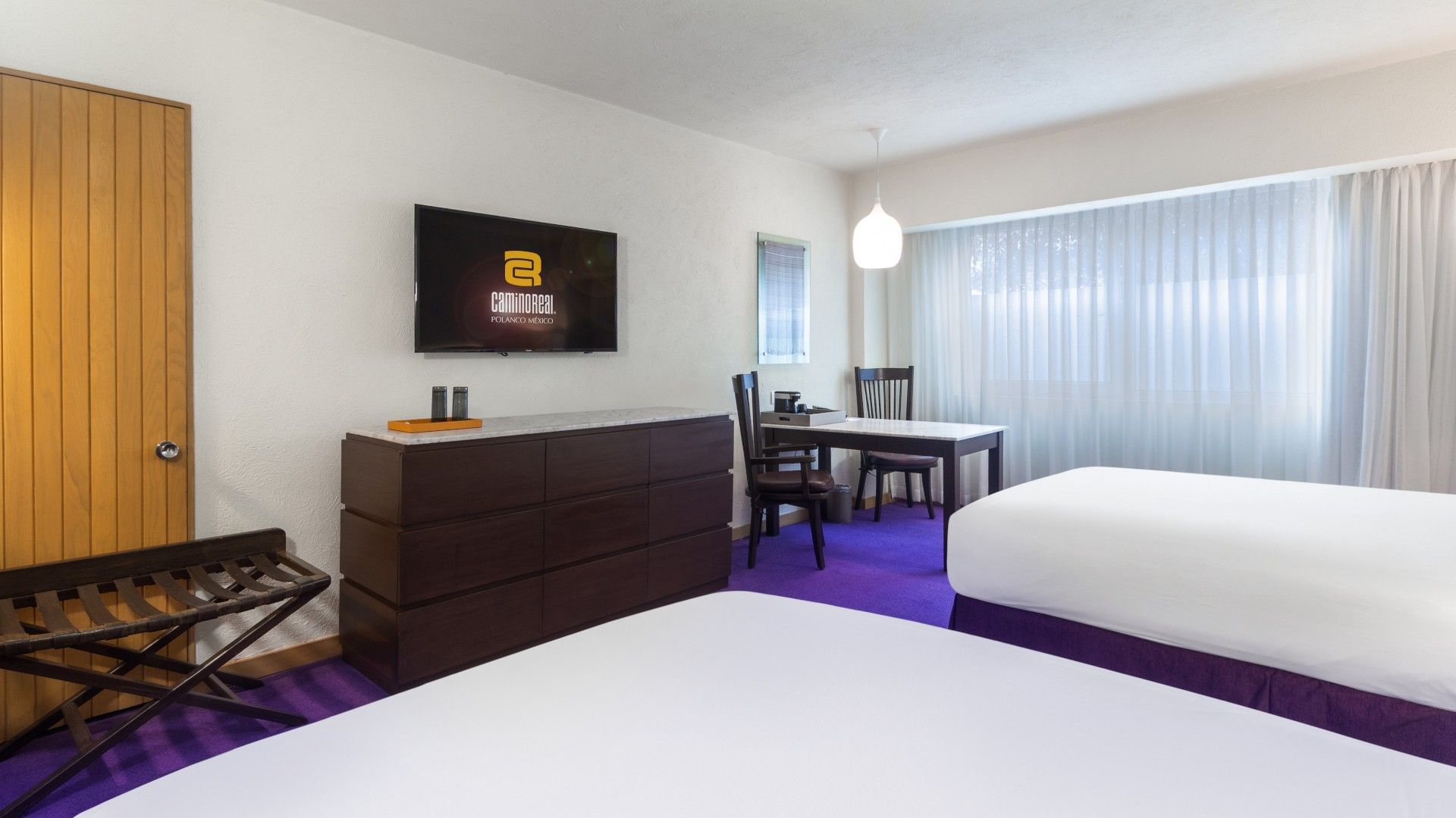 2 Double Superior Deluxe room with a flat-screen TV, wooden furniture, and purple flooring at Camino Real Polanco Mexico