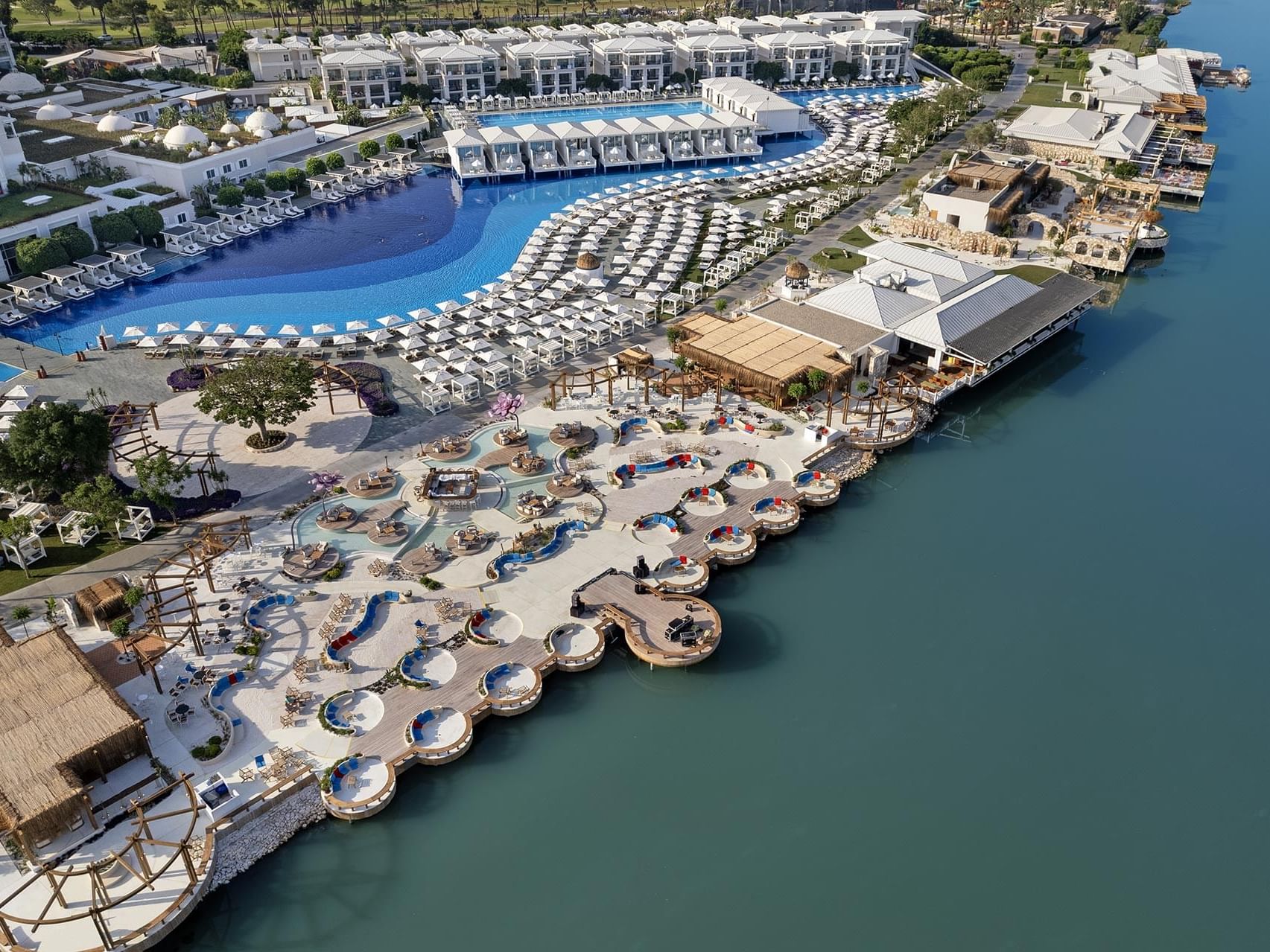 Aerial view of Titanic Deluxe Golf Belek with a large pool, cabanas, and oceanfront access