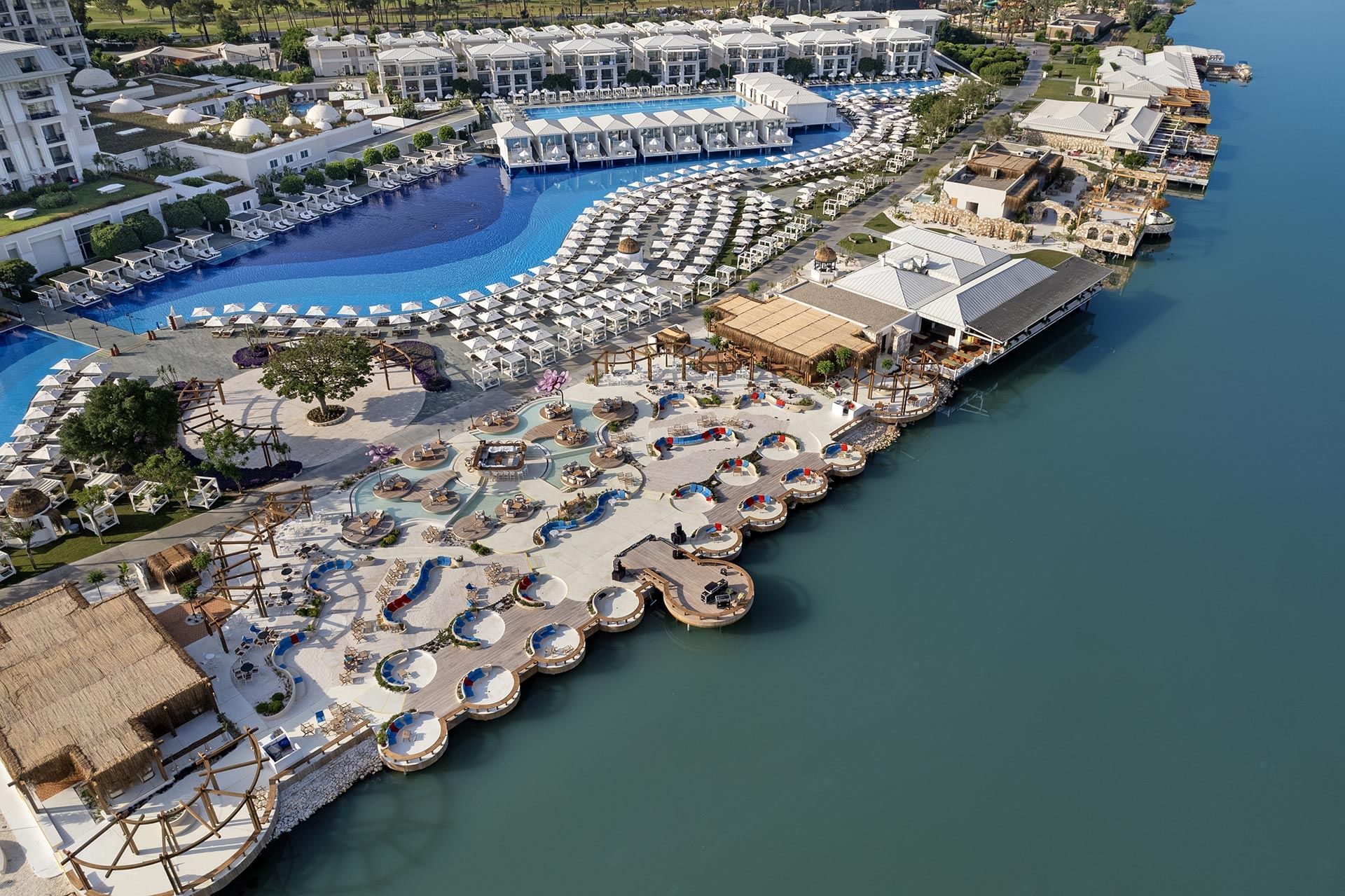 نمای هوایی Titanic Deluxe Golf Belek شامل استخرها، ساختمانها و حاشیه رود