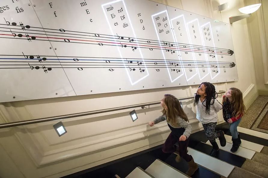 Haus der Musik in Wien mit interaktiver Noteninstallation und Kindern beim Entdecken von Musik