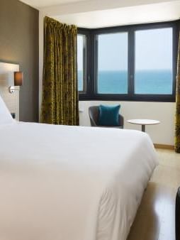 King bed & furniture in a room at Oceania Hotels Group
