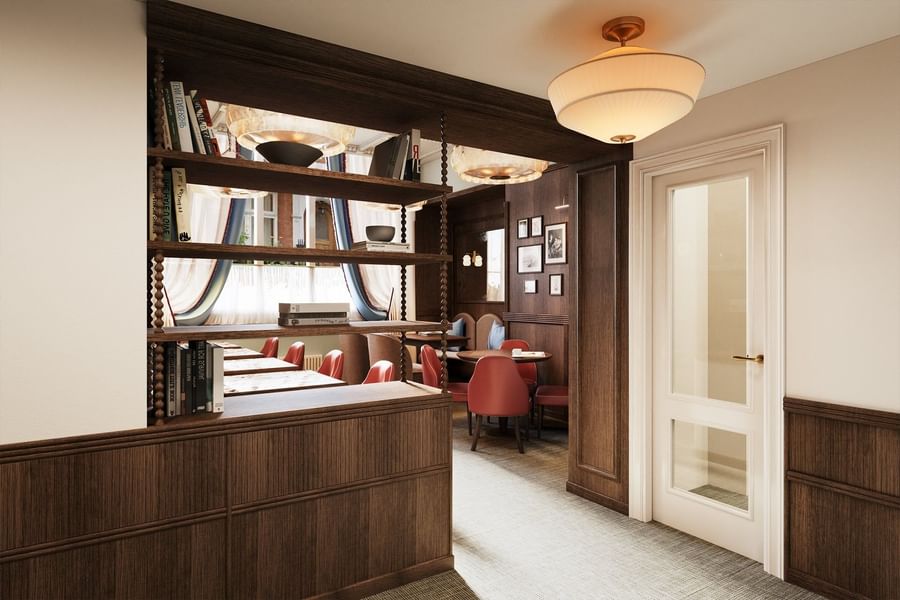 Open shelving unit placed by dining tables under hanging lamps at The Capital Hotel, Apartments and Townhouse