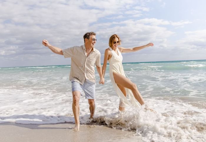 Couple playing & enjoying on the beach at Diplomat Beach Resort