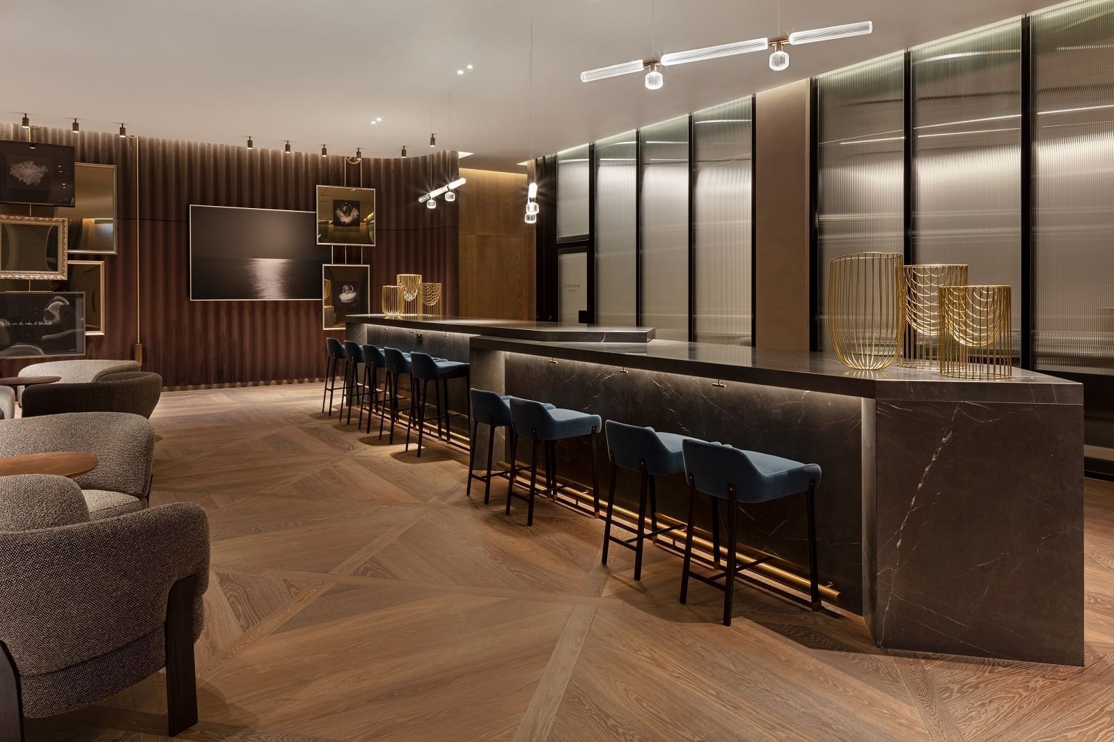 Art gallery featuring a sleek marble counter with blue stools at The Londoner