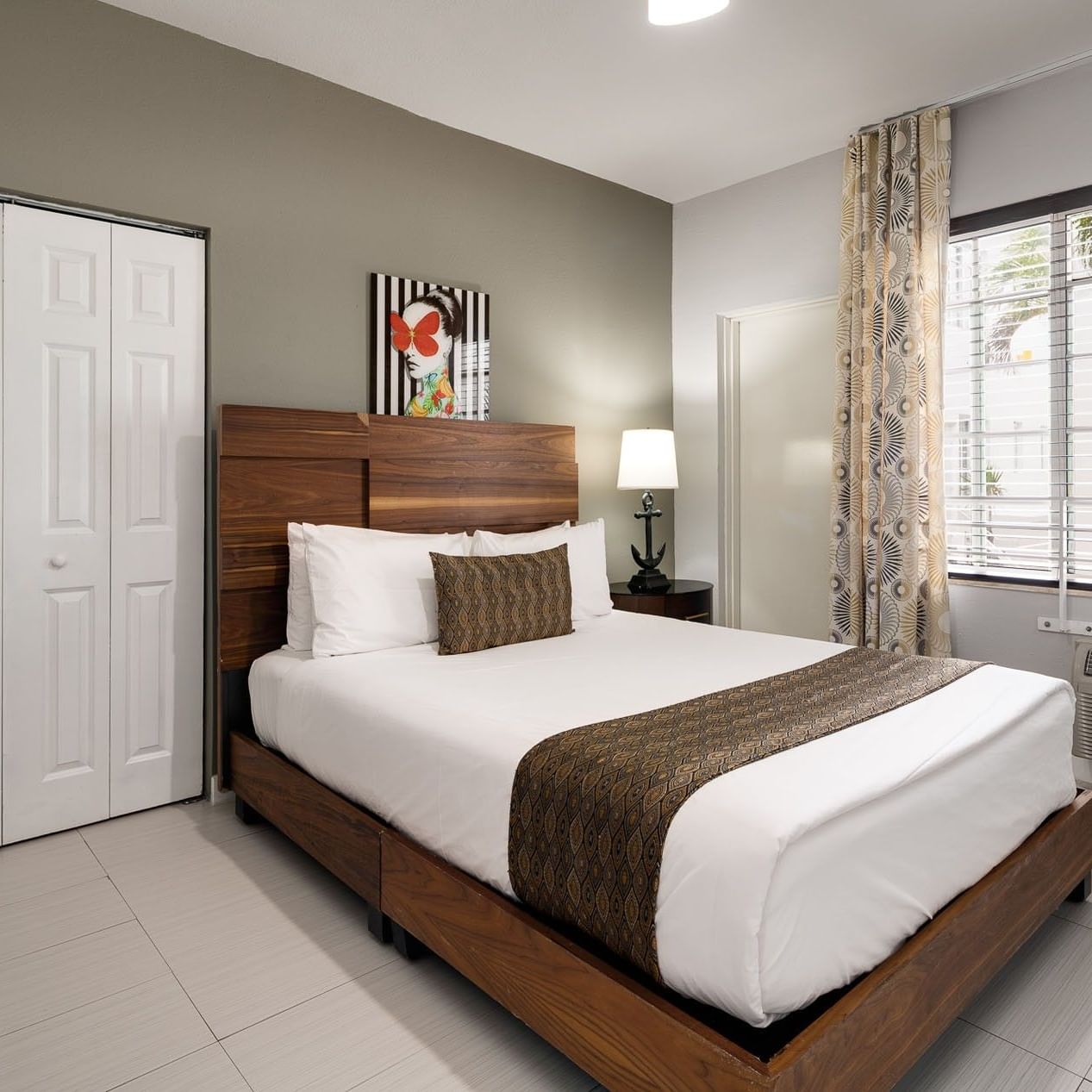 Pool View One Bedroom Queen Suite with a queen bed and a window at Tradewinds Apartment Hotel