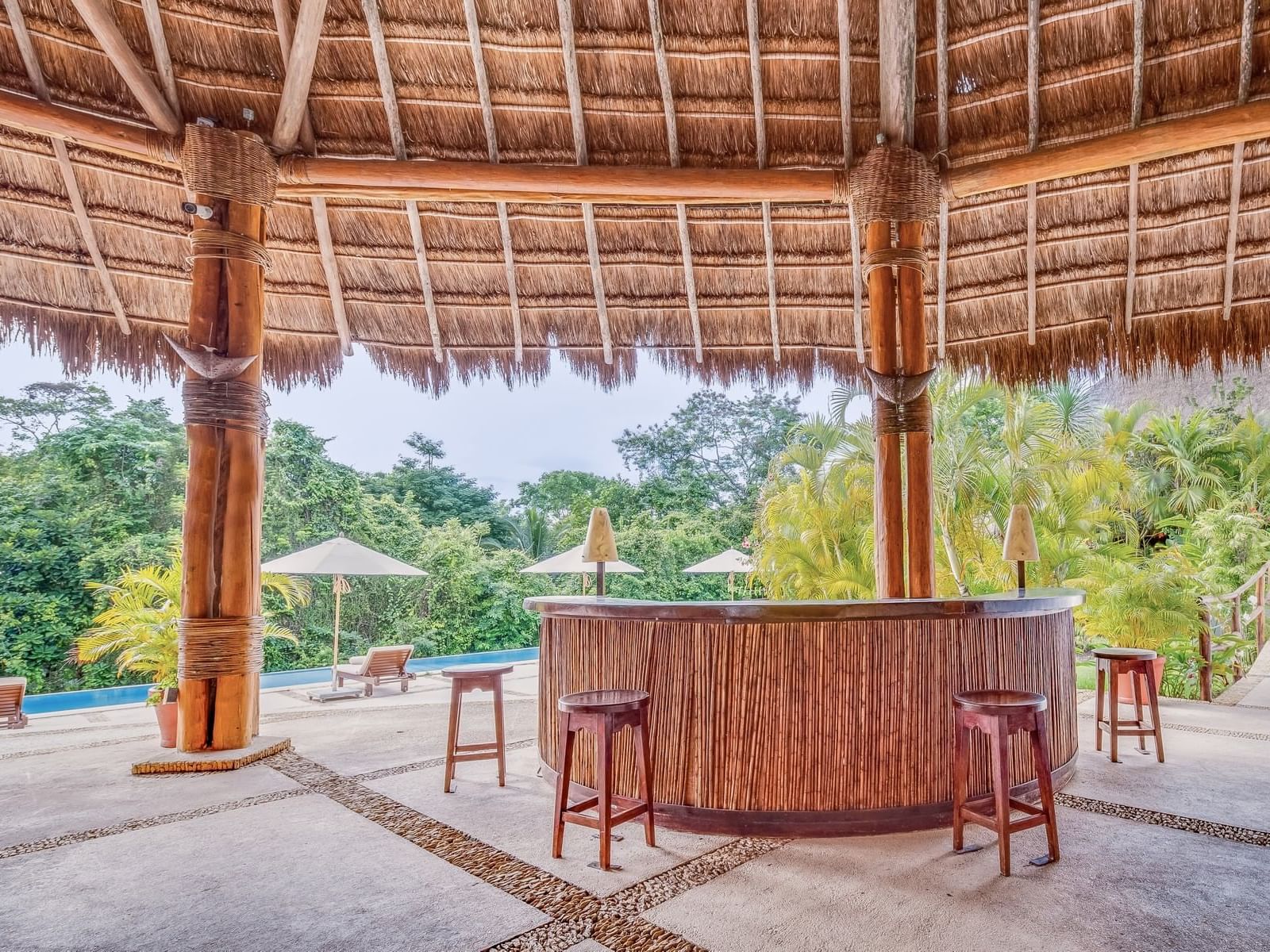 Bar with a straw roof next to the pool at La Colección Resorts