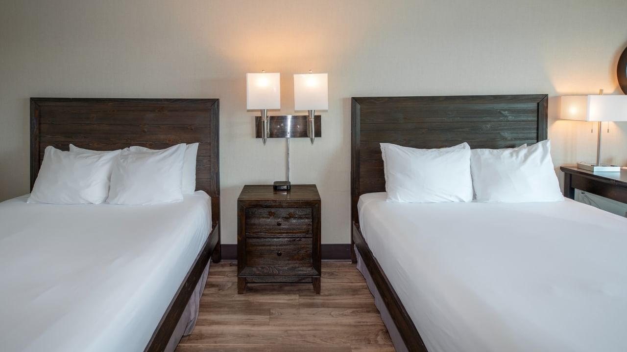 Coast Two Queens two queen beds, a nightstand with lamps, and wooden floor at Coast Lonsdale Quay Hotel