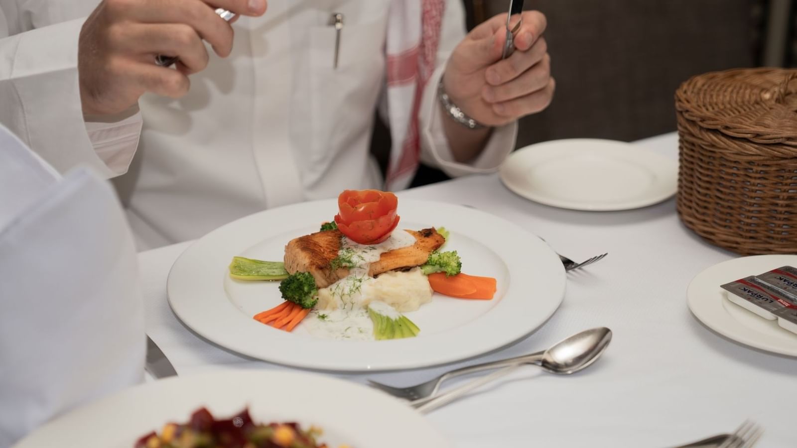 Close-up of a grilled salmon fillet served with mashed potatoes and vegetables in Al Duhaa restaurant at Saja Warwick Madinah