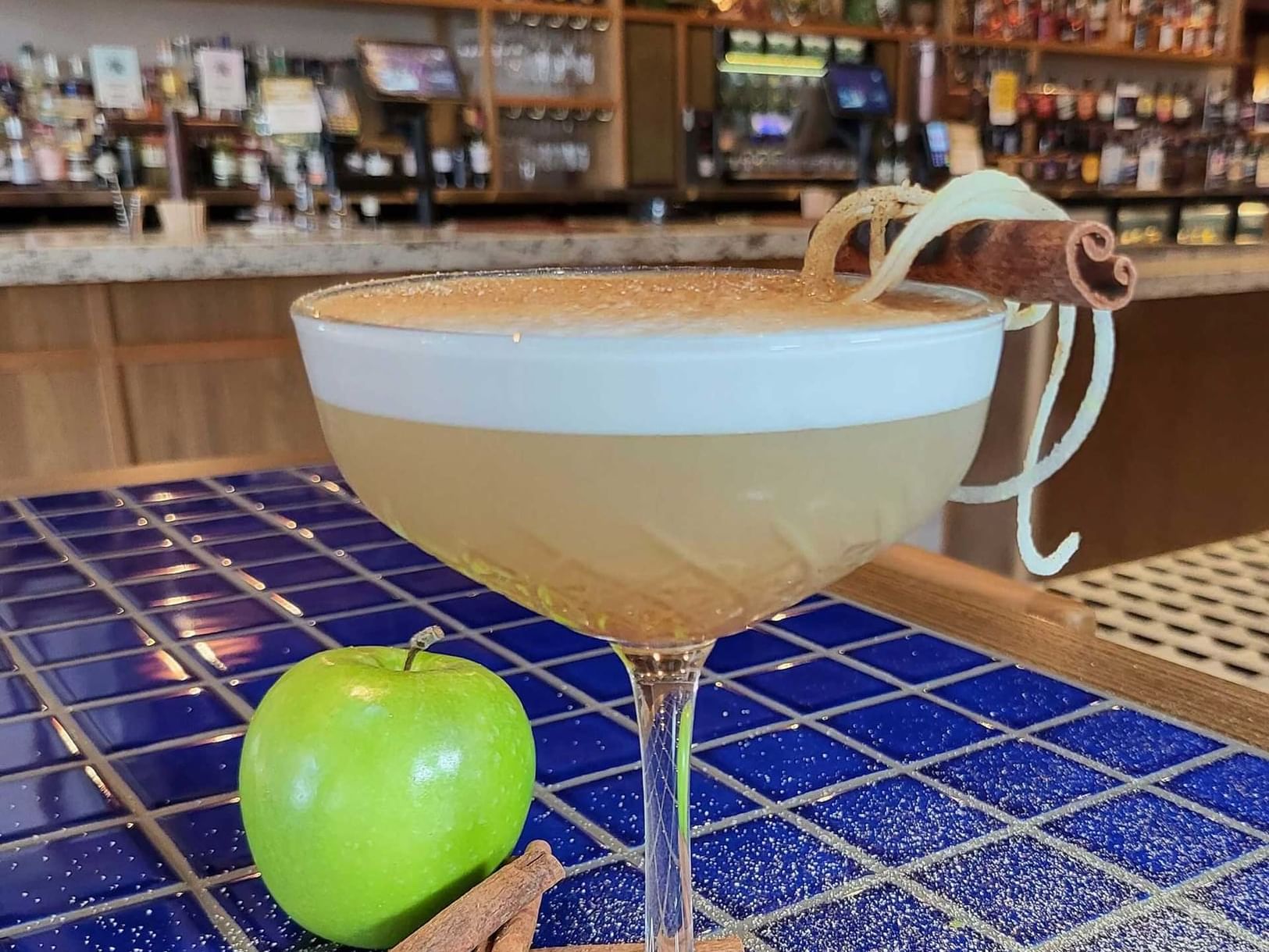 A cocktail presented with cinnamon and a green apple in Hadley's bar at Encore by Mingara