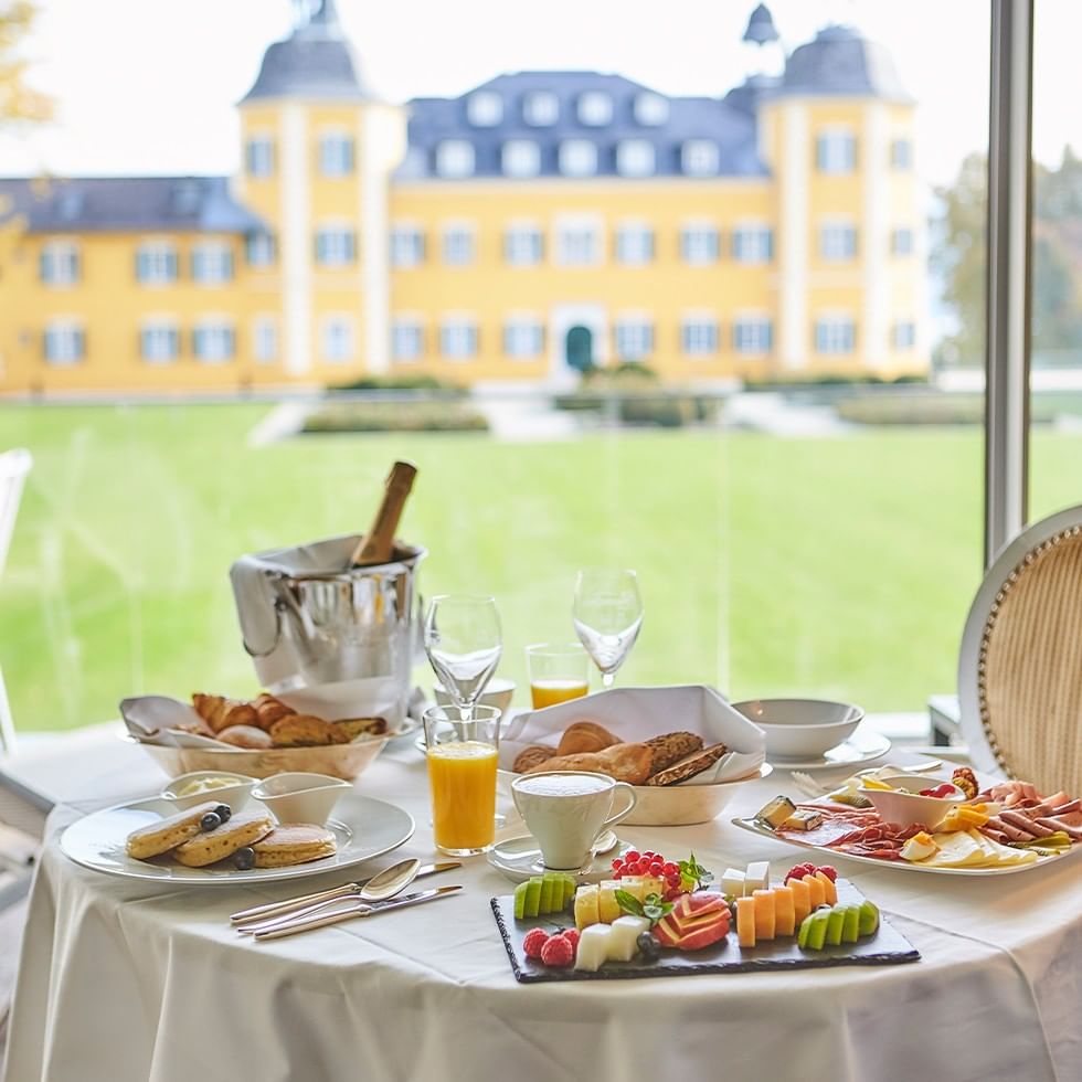 Feiner Valentinstag Brunch mit vielfältigen Speisen und Getränken vor Schlosskulisse.