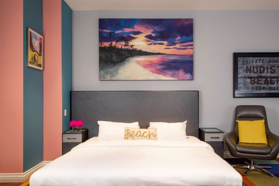 King bed, painting on the wall & comfy chair in King Superior South beach at Retro Suites Hotel