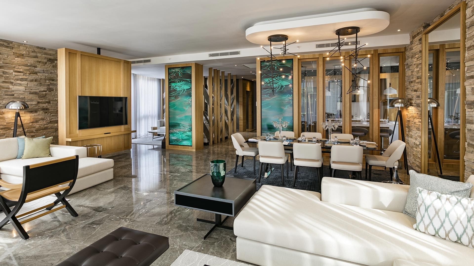 Presidential Villa's living room with couches, a dining area, and modern decor in a luxury setting at Titanic Luxury Collection Bodrum