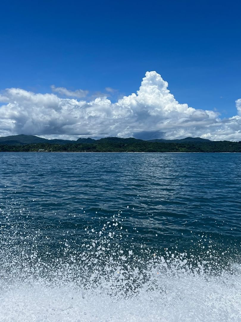 Sea spray by the deep blue ocean under fluffy white clouds near Warwick Le Lagon - Vanuatu in Efate
