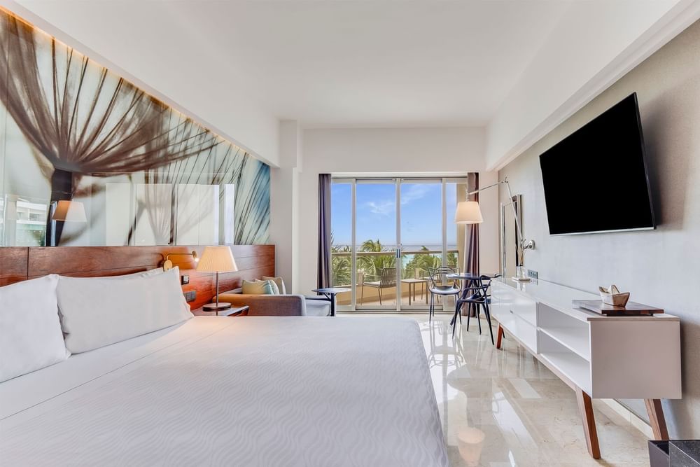 King bed and TV with seating area in Premium Partial Ocean View at Live Aqua Cancún
