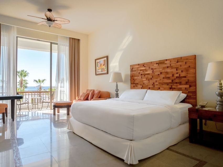 Junior Suite Garden View featuring a King-sized bed, couch and a balcony area at Marquis Los Cabos Resort