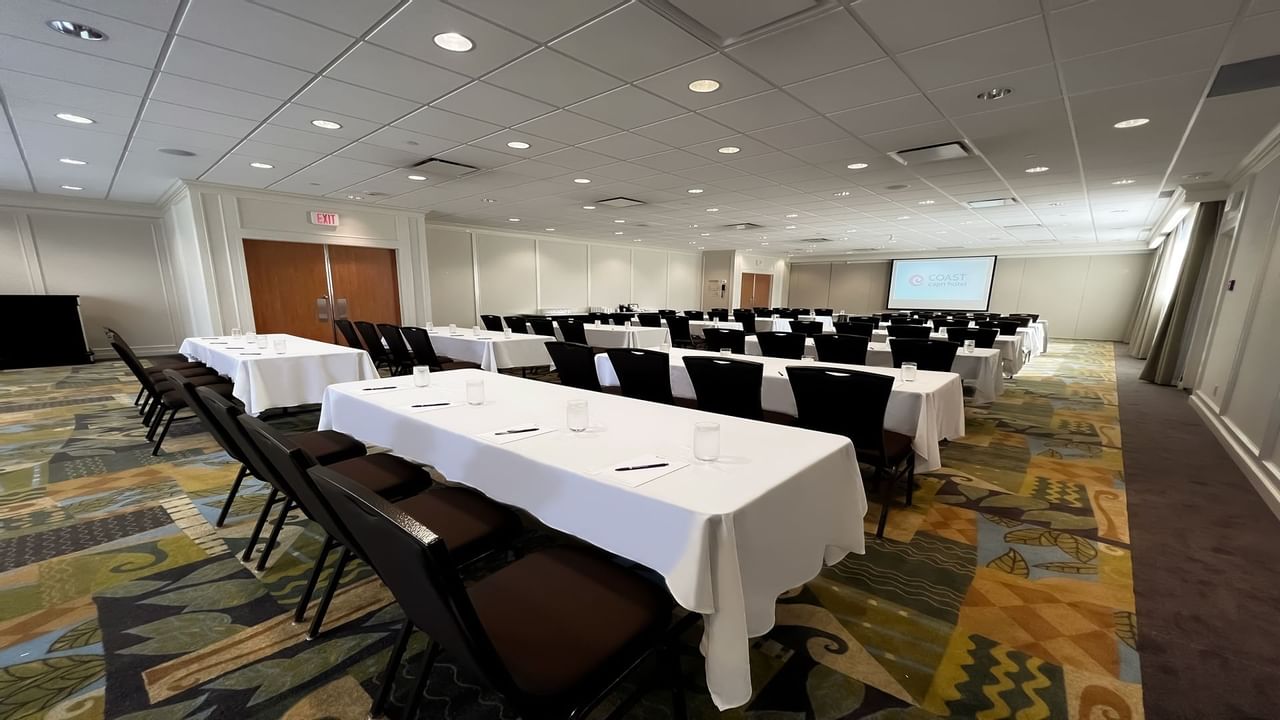 Tables facing presentation screen in spacious room