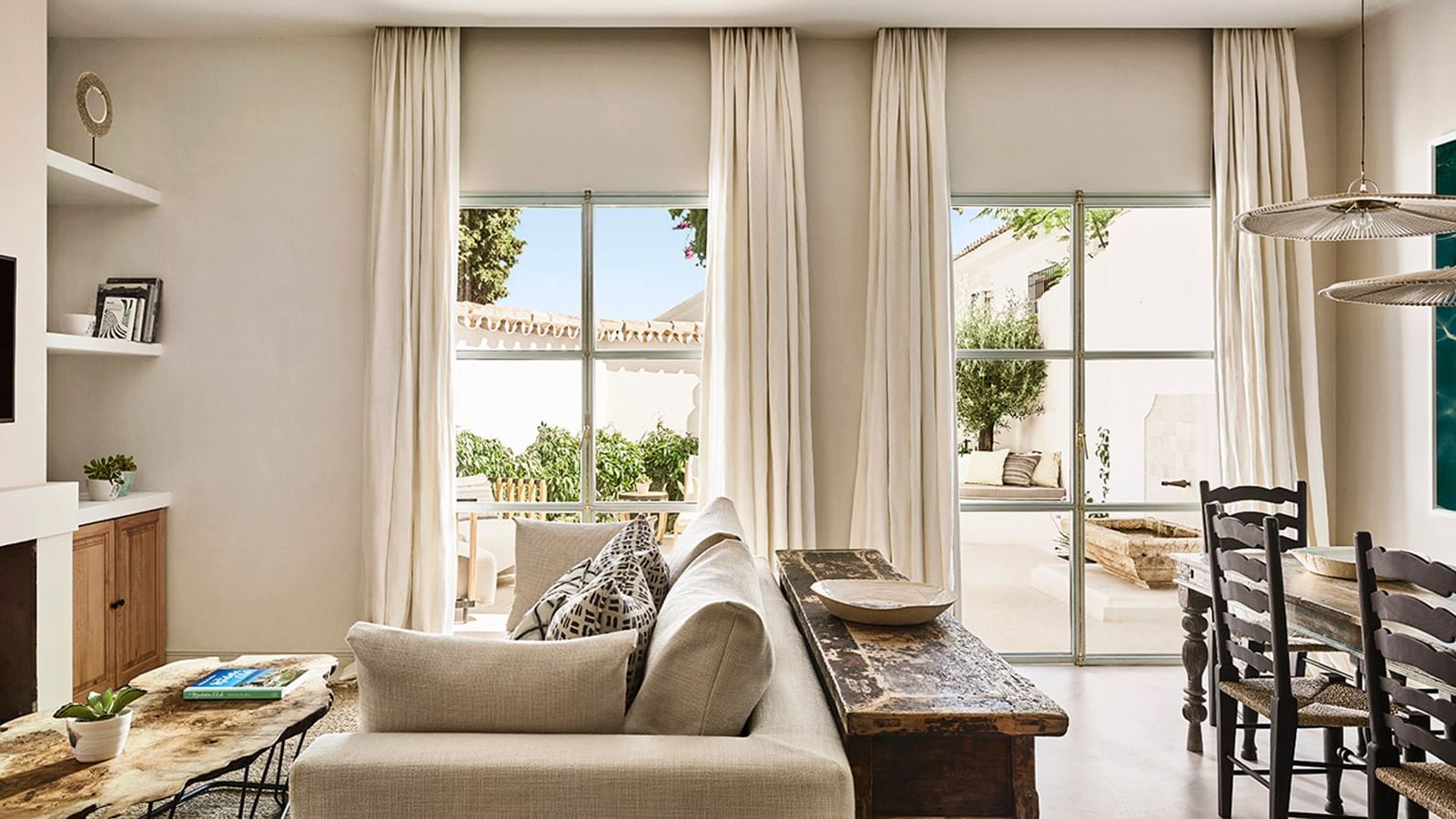 Chiquita with beige sofa placed by windows and a rustic wooden console at Marbella Club