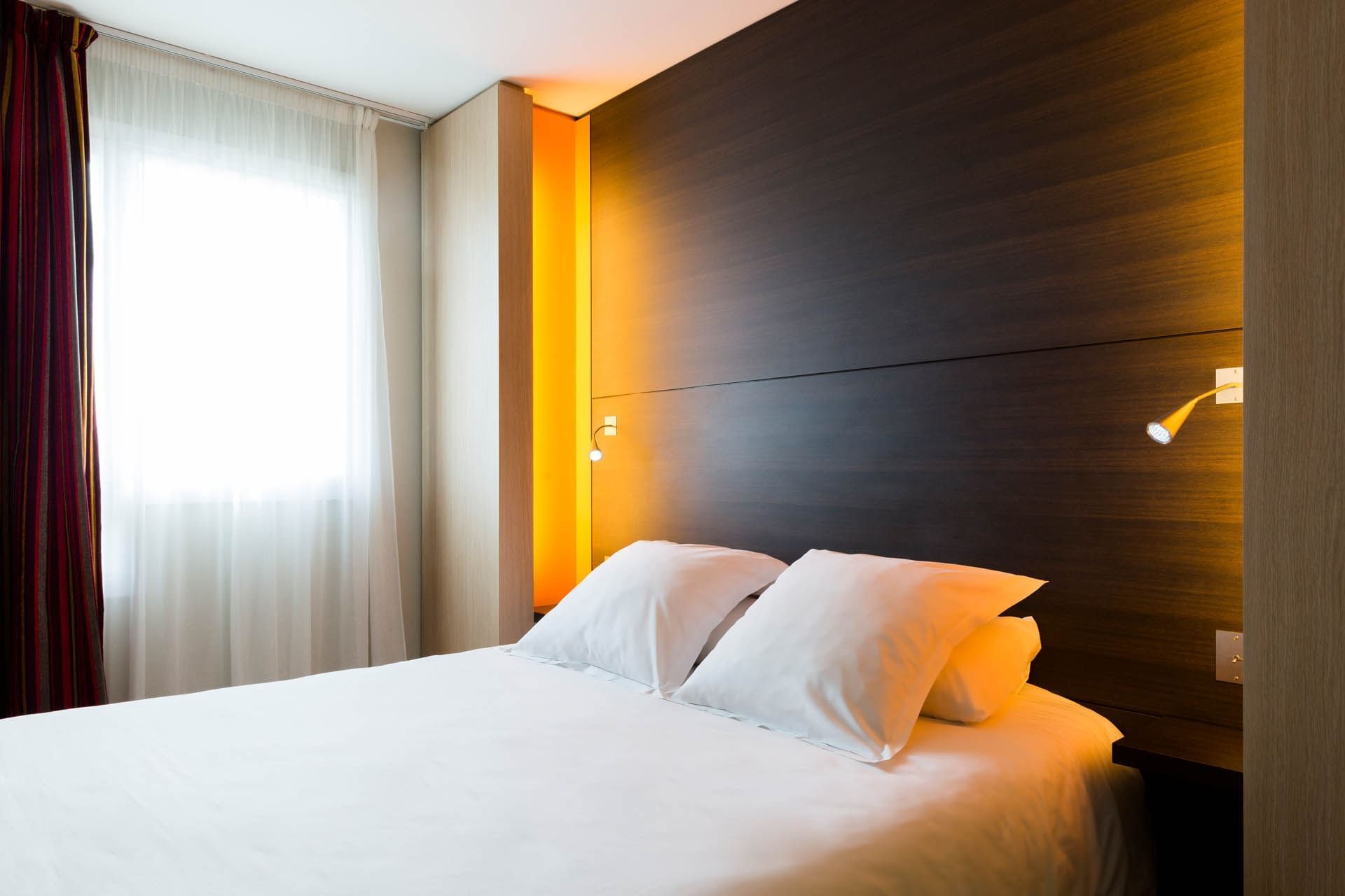 Comfy king bed in a room at Oceania Nantes Aéroport