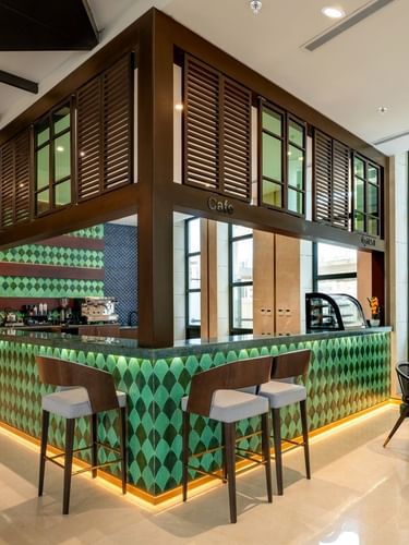 Bar counter with barstools in Lobby Café at Naviti by Warwick Jeddah, featuring fine dining inside a Boutique Hotel in Jeddah