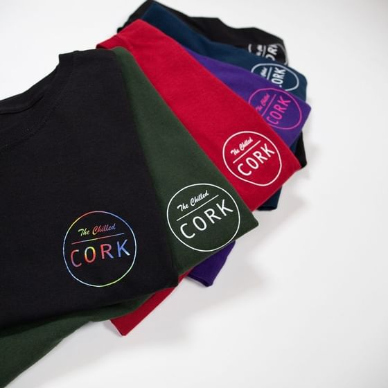 A row of folded t-shirts with Chilled Cork logo at Retro Suites