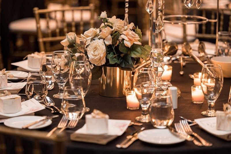 Table setting with candles and a floral centerpiece in a wedding ballroom at Sofitel Brisbane Central