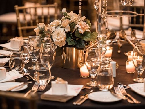 Table setting with candles, roses, and crystal glassware at Wedding in Sofitel Brisbane Central