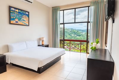 Room with king bed & furniture at Villas Sol Beach Resort