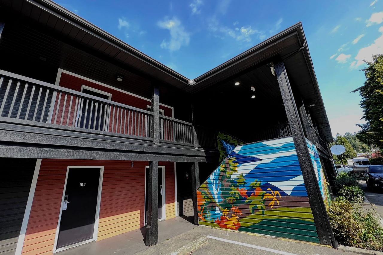 Guest room doors accompanying colorful artistic mural on stairwell