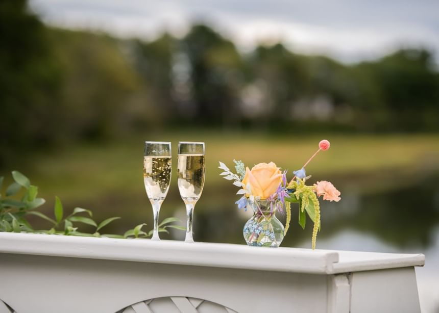 Close-up of two champagne glasses by flower decor in a wedding venue at Ogunquit River Inn