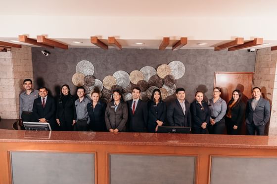 Hotel staff posing behind the front desk at Araiza Mexicali
