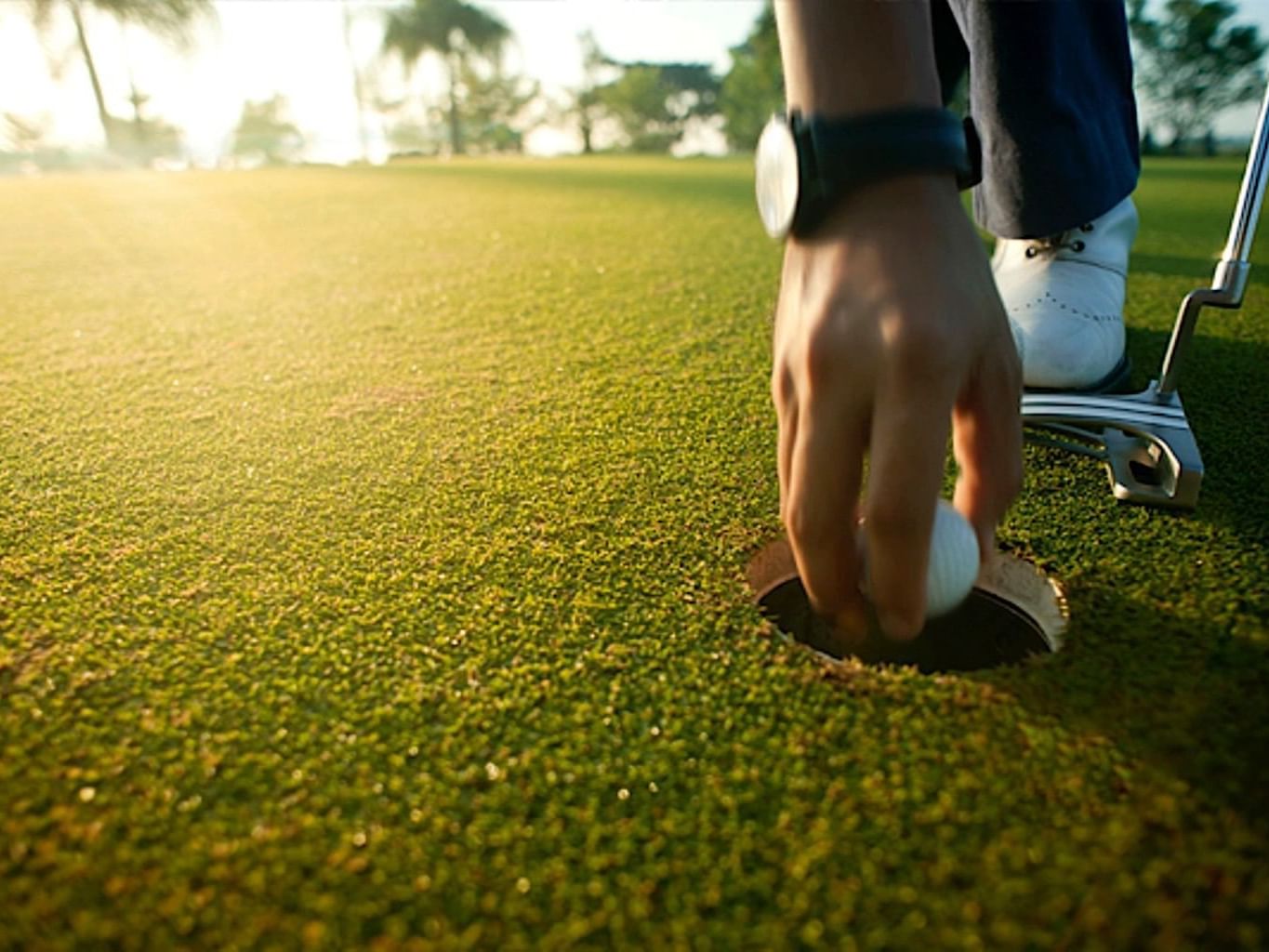 Man picking up a golf ball at Casa Colonial Beach and Spa