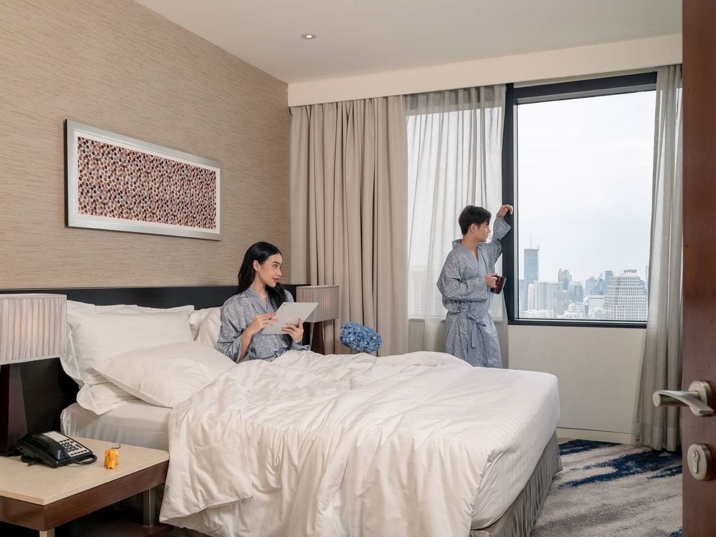 Couple relaxing in robes in a room at Chatrium Hotels