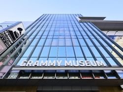 A view from below looking up at the entrance and main sign of the Grammy Museum in Los Angeles