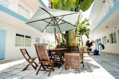 Courtyard patio with a table patio umbrella in Aqua Hotel
