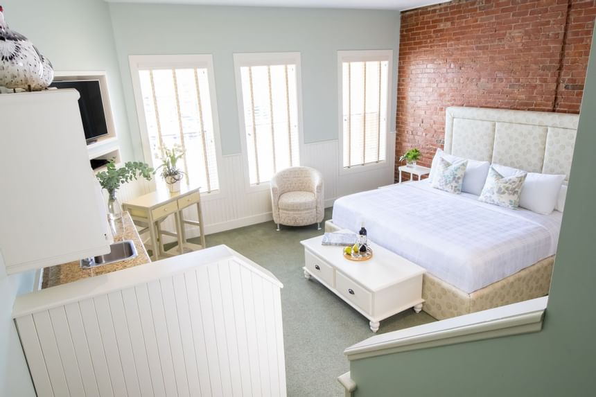Elevated view of the bed, work desk, brick wall & furniture in Premiere Loft Nantucket at Retro Suites Hotel