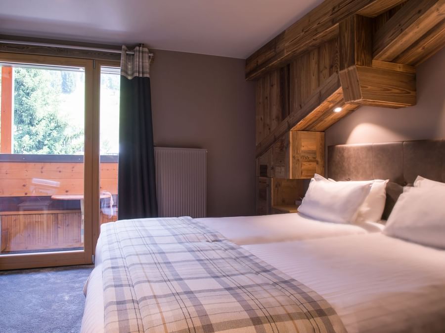 Queen bed in a Superior Room at Chalet-Hotel Les Gentianettes
