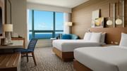 Oceanfront queen room with modern furnishings and panoramic water views.