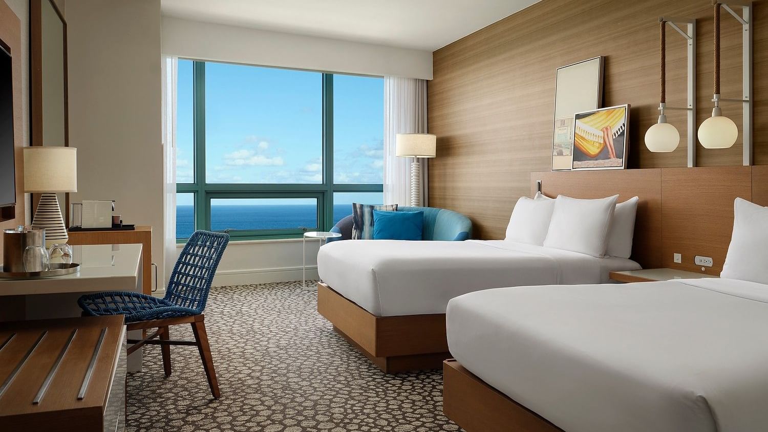 Oceanfront queen room with modern furnishings and panoramic water views.