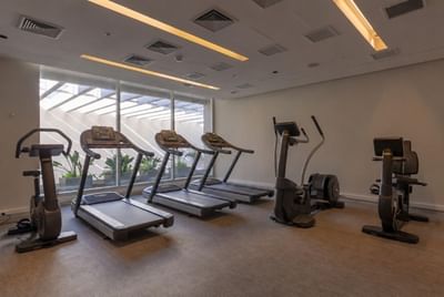 Fitness center featuring professional treadmills and exercise bikes positioned by windows at Veranda Hotel