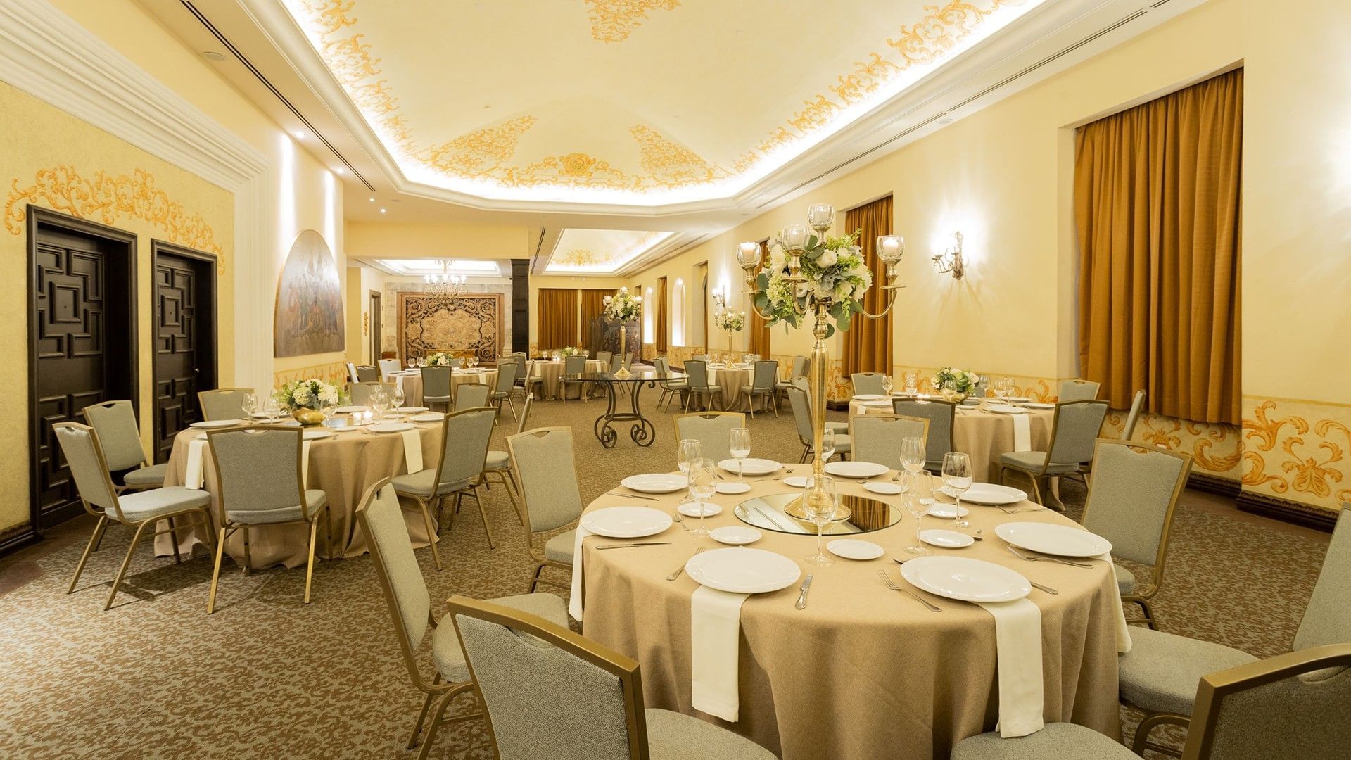 Salon Torre Ejecutiva with ornate ceiling details and elegant circular table setups at Quinta Real Monterrey