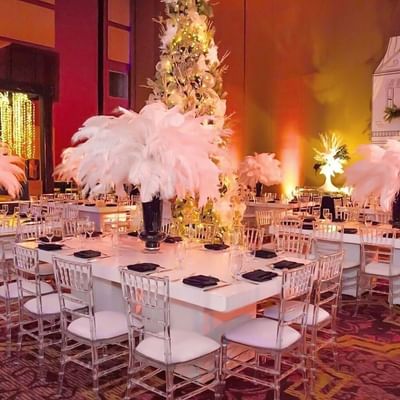 White feathery centerpieces are placed on a dining table surrounded by clear chairs at the Megapolis Hotel Panama