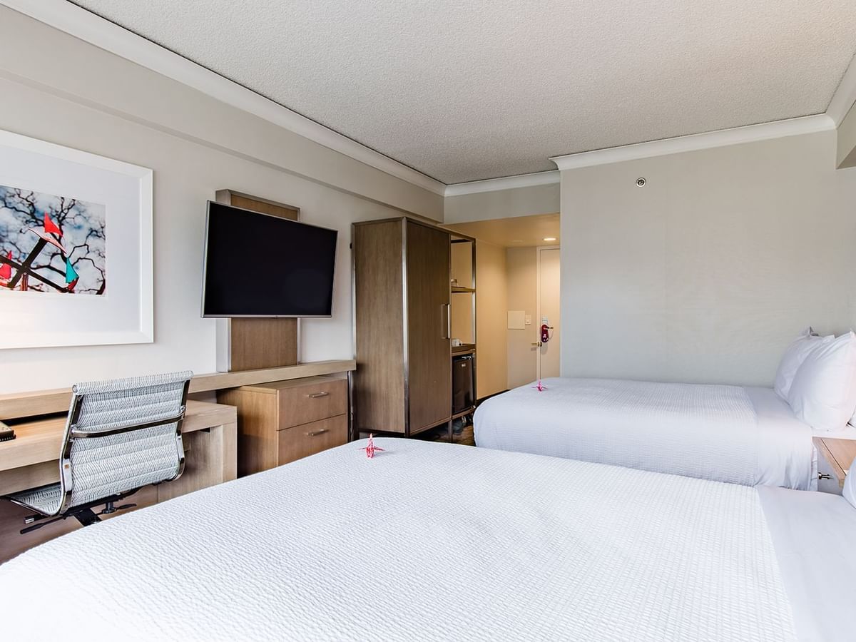 Accessible hotel guestroom with two beds, TV, and desk
