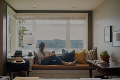 Lady sitting on the window lounge in Waterfront Queen at Alderbrook Resort & Spa
