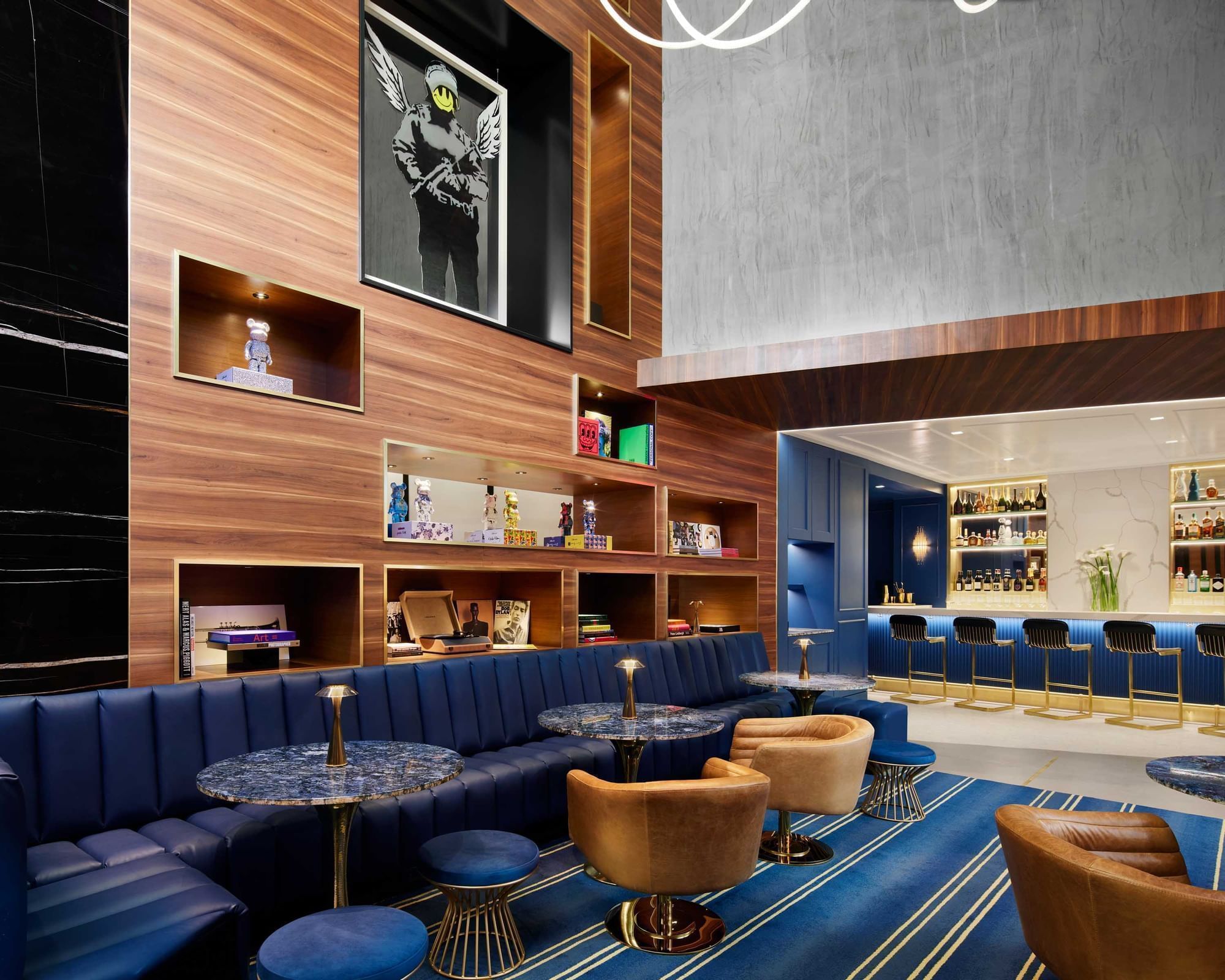 Gansevoort Meatpacking NYC lobby with blue banquets, chairs and a custom walnut bookshelf with art