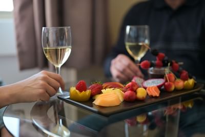 Close-up of a couple enjoying a fresh fruit platter paired with white wine at Rodd Grand Yarmouth