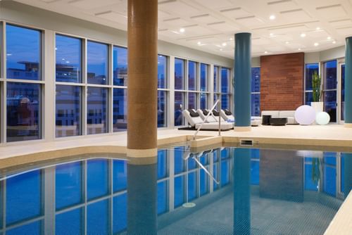 Indoor pool area with loungers at  Warwick Le Crystal