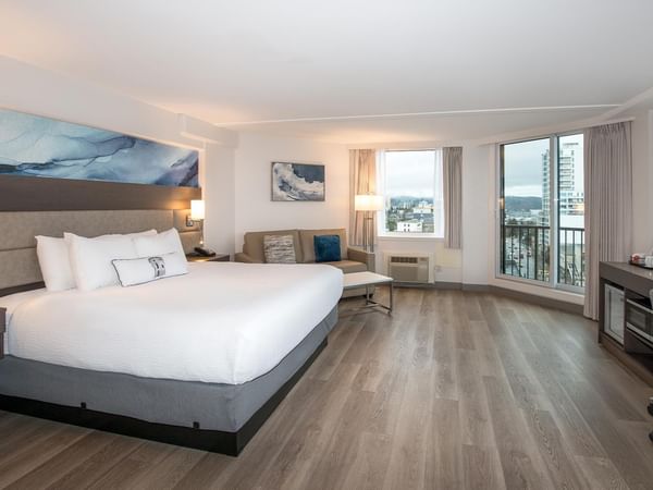 King size bed and ocean view in a room at Coast Bastion Hotel in Nanaimo.