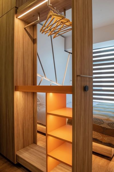 Wooden wardrobe with hanging racks in Standard King Room at Hotel Nodo, featuring the coziest hotel rooms in Santiago, Chile